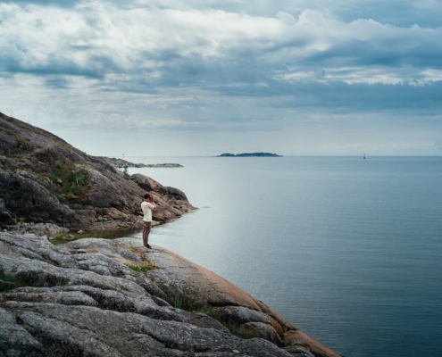 Man standing on a cliff, sea, clouds
