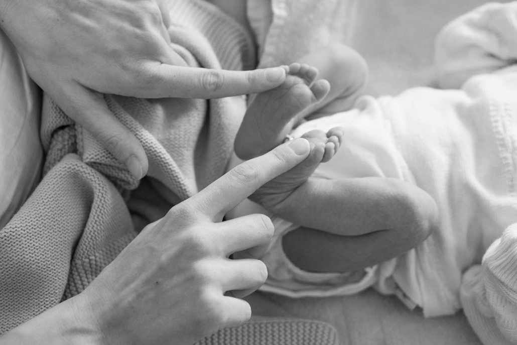 Newborn's feet and mother's fingers