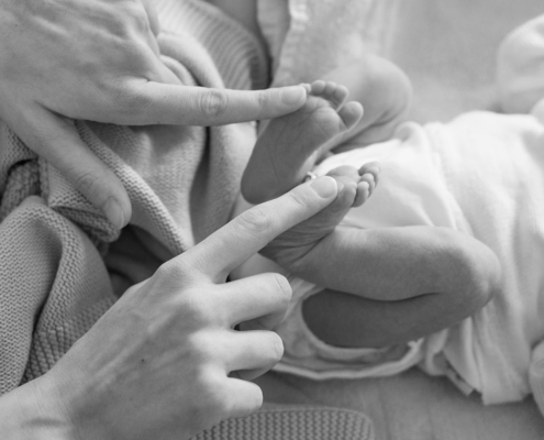 Newborn's feet and mother's fingers