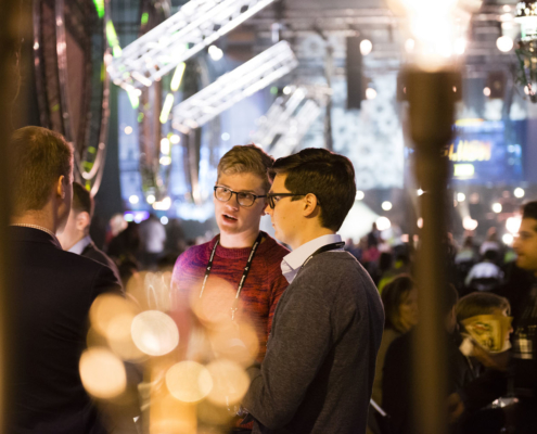 Three people discussing in Slush exhibition