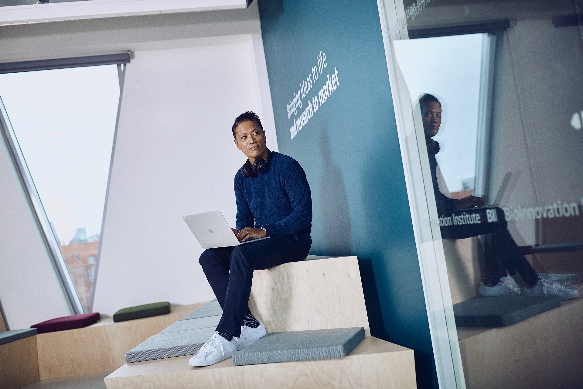 A man sitting and holding a laptop