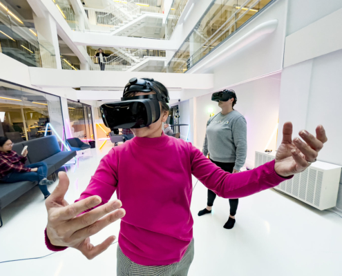 Woman in a pink shirt testing VR glasses