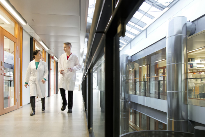 Two researchers in lab coats walking