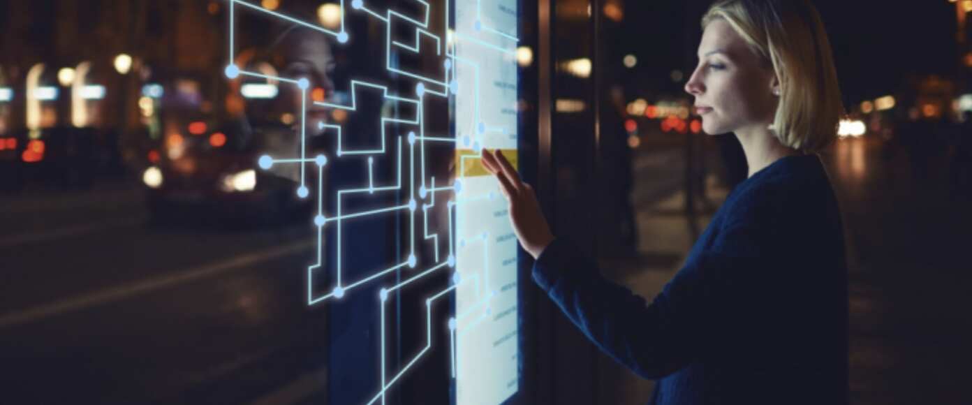 A woman in front of a touch screen